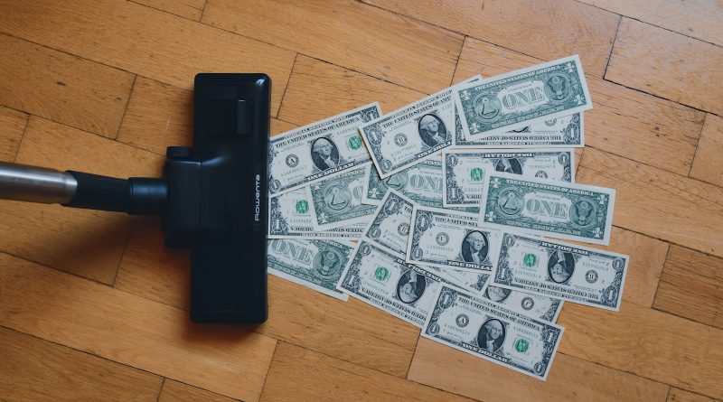 a pile of money sitting on top of a wooden floor